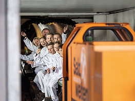 Salzwelten Salzburg - Besucher bei der Fahrt mit der Grubenbahn tief in den Berg