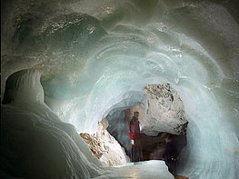 Eisriesenwelt Werfen - Ein Mann in der Eishöhle mit Laterne vor einem Eisdurchgang