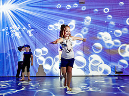 Krimml Worlds of Water - children at the interactive exhibition on "Faces of Water" with water projection on the walls