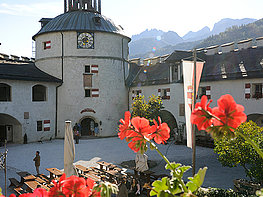 Erlebnisburg Hohenwerfen - Blick durch rote Blumen auf den Burghof