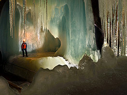 Eisriesenwelt Werfen - man on the ice with a view of the icicles of the ice organ inside the cave