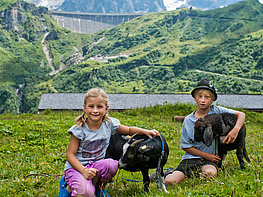 Kaprun Alpine Reservoirs - children with goat and sheep on the Fürthermoaralm